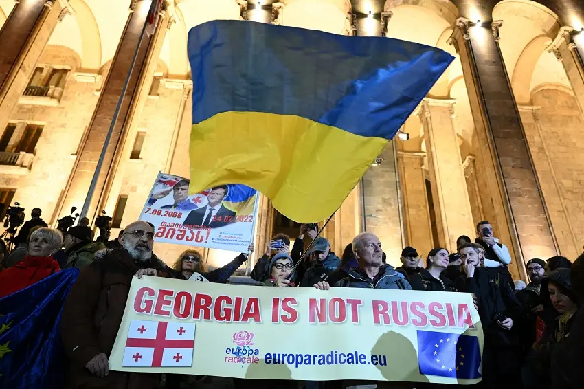 Protestanter med ukrainsk flagga och banner som lyder "Georgia is not Russia".